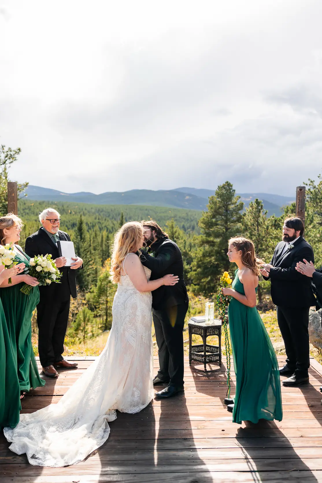 Pricing A wedding ceremony taking place outdoors in front of a scenic mountain landscape backdrop.