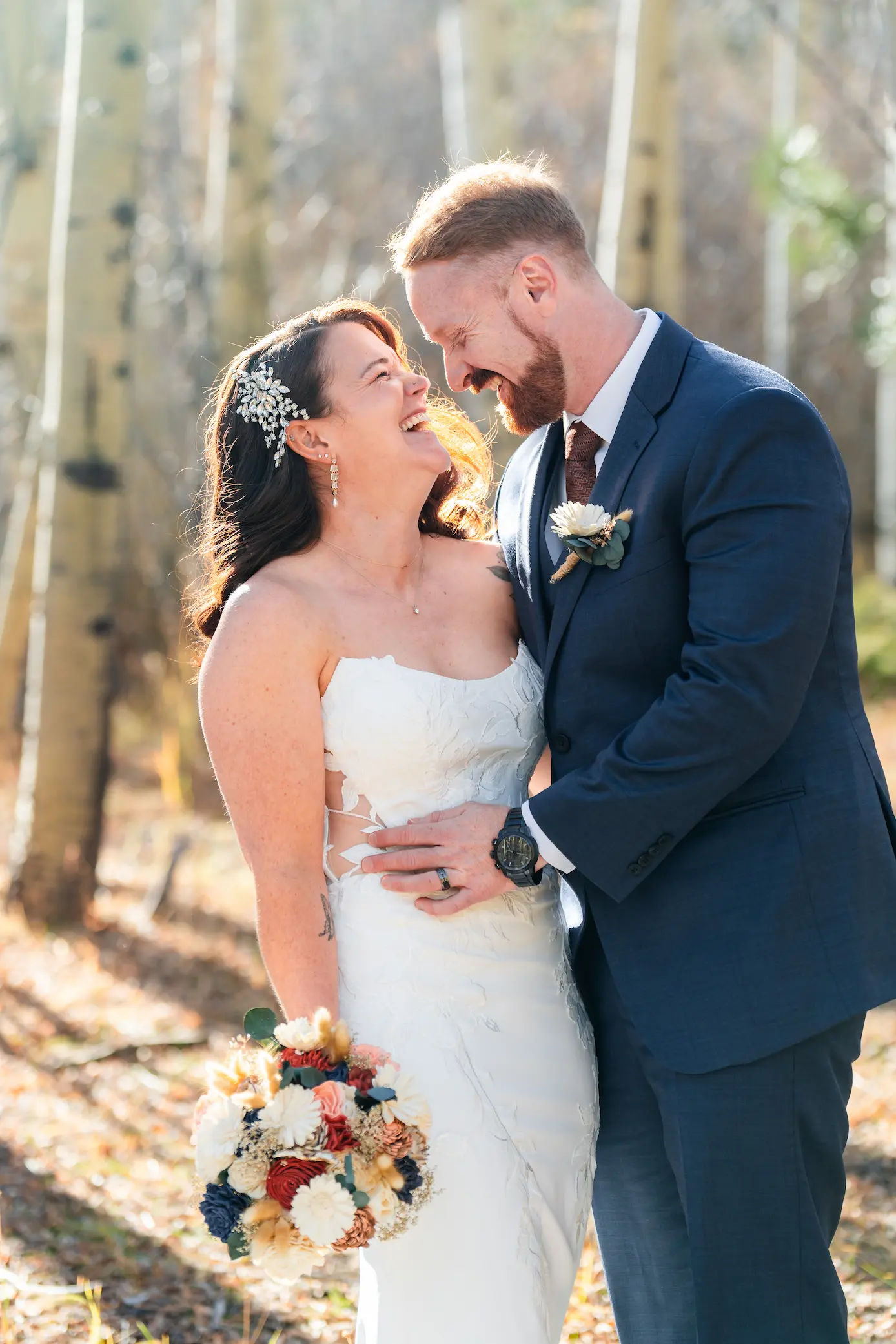 Pricing A happy bride and groom laughing together outdoors during a wedding photography session in an aspen forest.